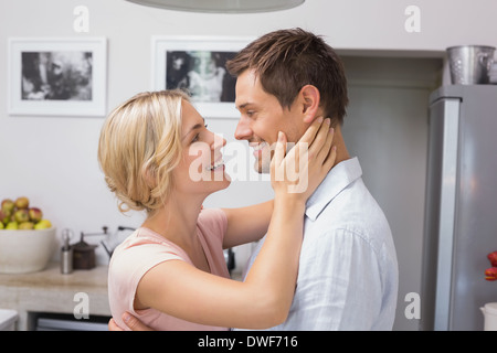 Loving couple looking at each other in kitchen Stock Photo