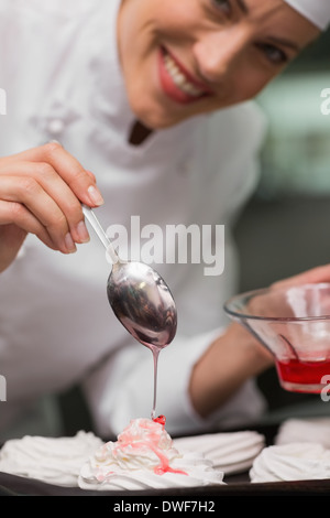 Chef pouring syrup over meringues Stock Photo