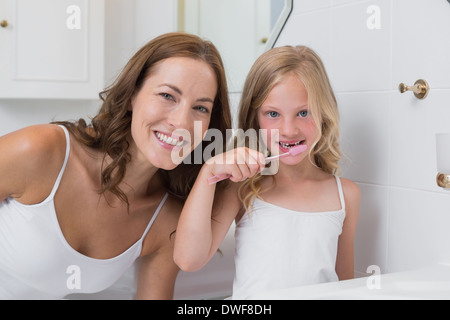 Portrait of mother with daughter brushing teeth Stock Photo