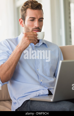 Handsome businessman working on laptop drinking espresso Stock Photo