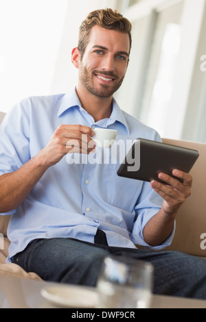 Handsome businessman working on tablet pc drinking espresso Stock Photo
