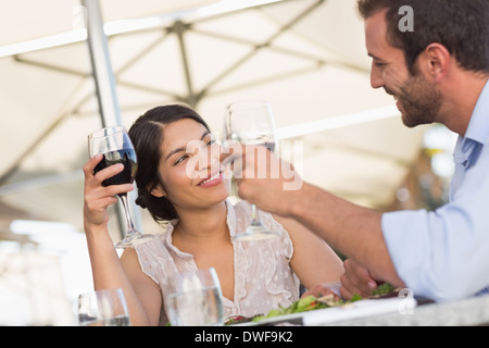 Happy couple on a date drinking red wine Stock Photo