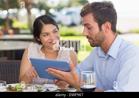 Happy couple on a date using tablet pc Stock Photo