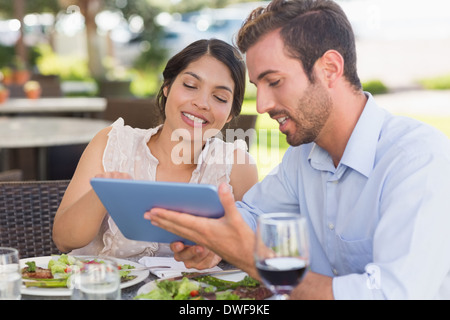 Happy couple on a date using tablet pc Stock Photo