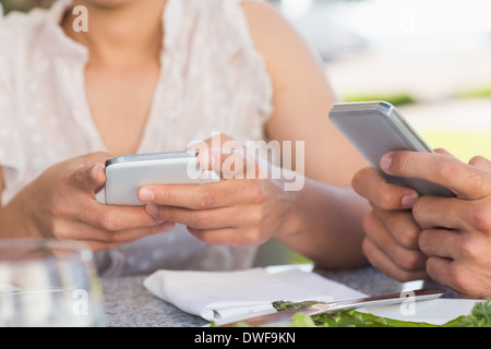 Couple on a date sending text messages Stock Photo