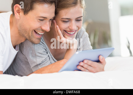 Happy couple on bed using tablet pc Stock Photo