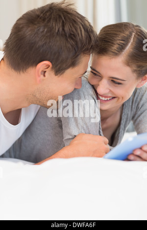 Happy couple on bed using tablet pc Stock Photo