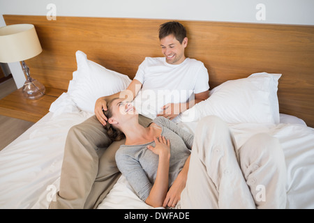 Happy couple relaxing on bed Stock Photo