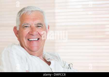 Happy senior man sitting on the couch Stock Photo