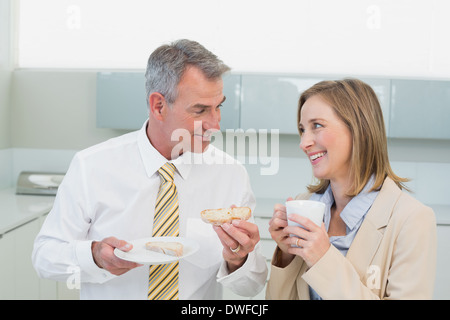 Business couple having breakfast in kitchen Stock Photo