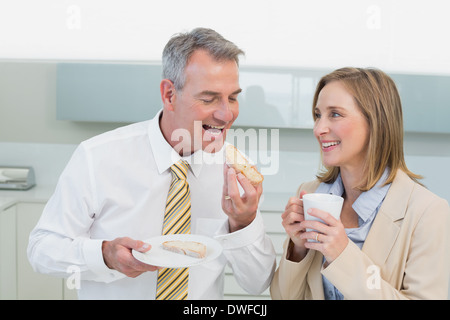 Happy business couple having breakfast in kitchen Stock Photo