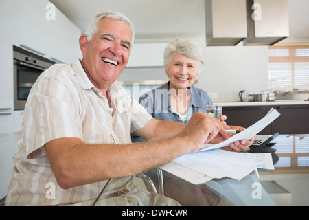 Happy couple paying their bills at the table Stock Photo