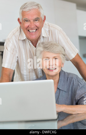 Happy senior couple using the laptop at the table Stock Photo