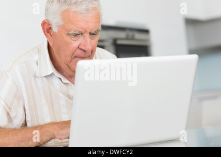 Confused senior man using the laptop at the table Stock Photo