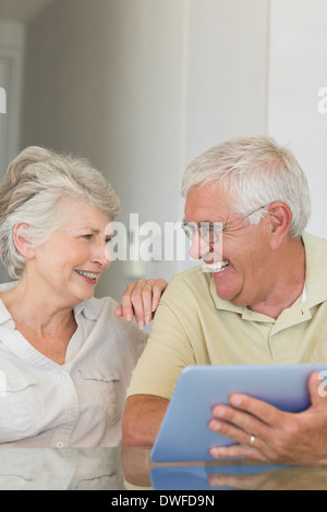 Happy senior couple using tablet pc at the table Stock Photo