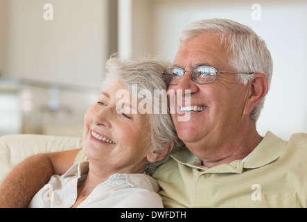 Senior couple sitting on couch relaxing together Stock Photo