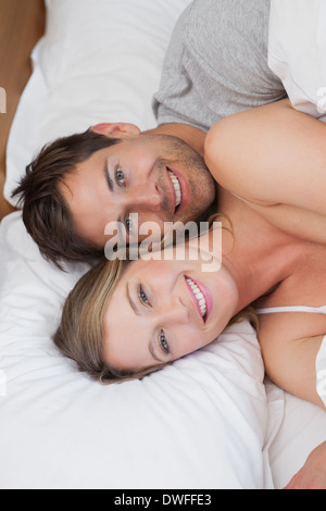 Happy relaxed young couple together in bed Stock Photo