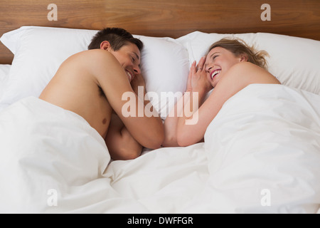 Happy relaxed young couple in bed Stock Photo