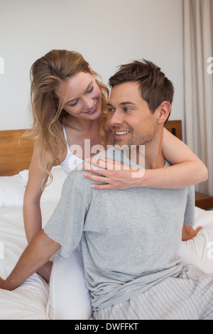 Loving relaxed young couple in bedroom Stock Photo