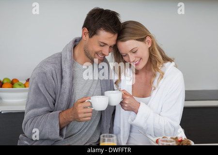 Young couple with coffee cups in kitchen Stock Photo