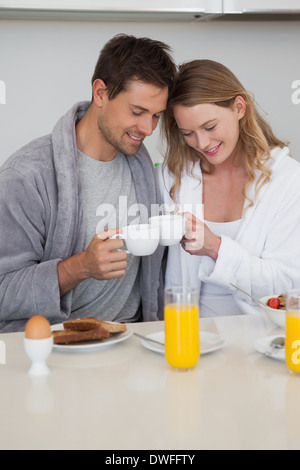 Young couple with coffee cups in kitchen Stock Photo