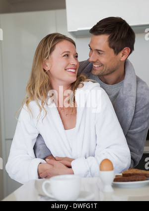 Loving young couple looking at each other in kitchen Stock Photo