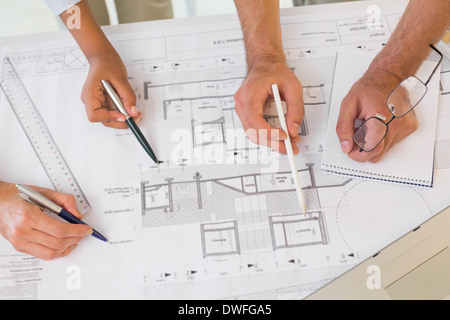 Several hands working on blueprints Stock Photo