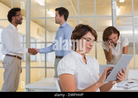 Businesswoman using digital table with colleagues at office Stock Photo