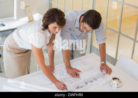 Business people working on blueprints at office Stock Photo