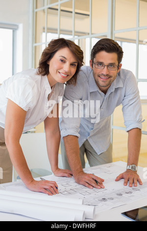 Two business people working on blueprints at office Stock Photo