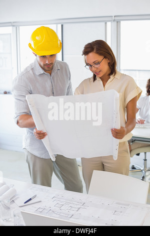 Concentrated colleagues working on blueprints at office Stock Photo