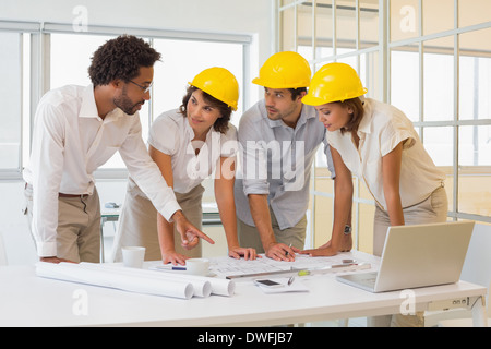 Colleagues working on blueprints at office Stock Photo