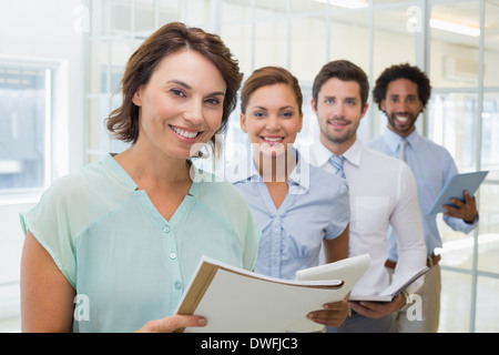 Business colleagues holding notepads in row at office Stock Photo