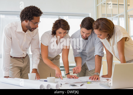 Business people working on blueprints at office Stock Photo