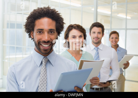 Business colleagues holding notepads and digital tablet in row Stock Photo