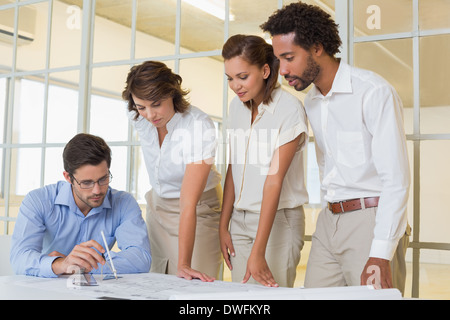 Business colleagues working on blueprints at office Stock Photo