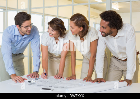 Business colleagues working on blueprints at office Stock Photo