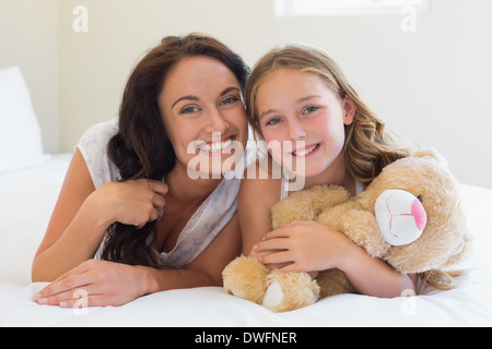 Woman with daughter lying in bed Stock Photo