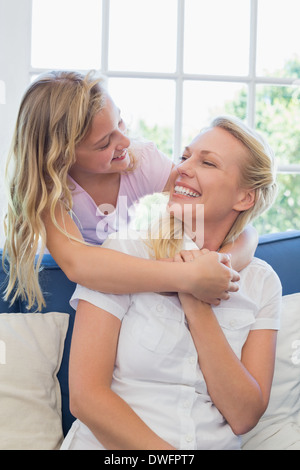Mother looking at daughter embracing her from behind Stock Photo