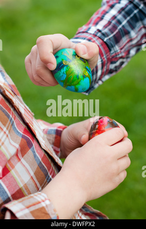 Two children hands hold Easter eggs Stock Photo