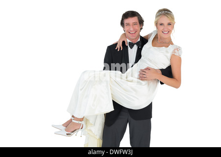 Handsome groom carrying bride Stock Photo