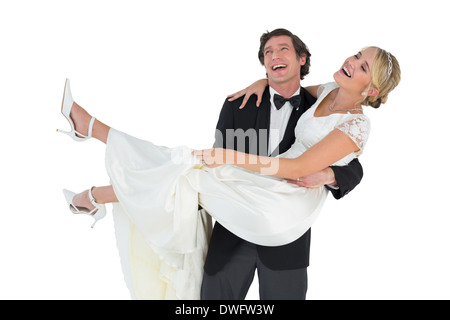 Cheerful groom carrying bride Stock Photo