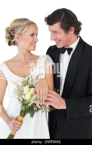 Bride and groom wearing wedding rings over white background Stock Photo