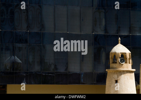 Traditional Minaret tower in Qatar with modern office block behind Stock Photo