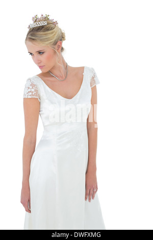 Thoughtful bride looking down over white background Stock Photo