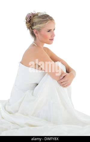 Bride hugging knees over white background Stock Photo