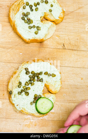 Preparing lox delight sandwich with fresh croissant. Stock Photo