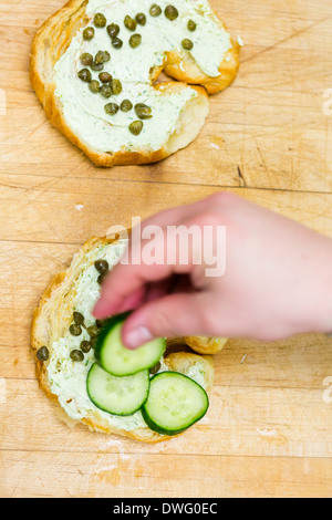 Preparing lox delight sandwich with fresh croissant. Stock Photo