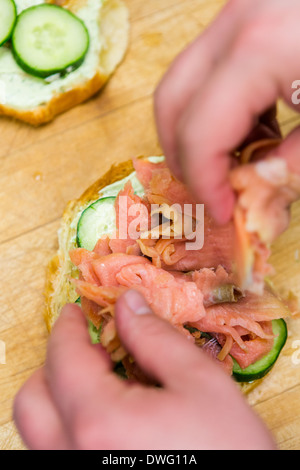 Preparing lox delight sandwich with fresh croissant. Stock Photo