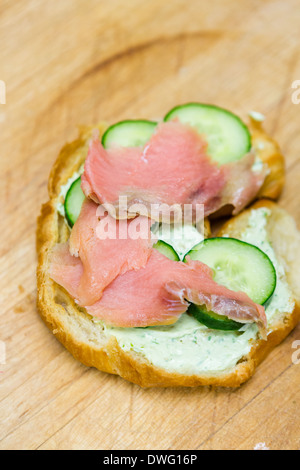 Preparing lox delight sandwich with fresh croissant. Stock Photo